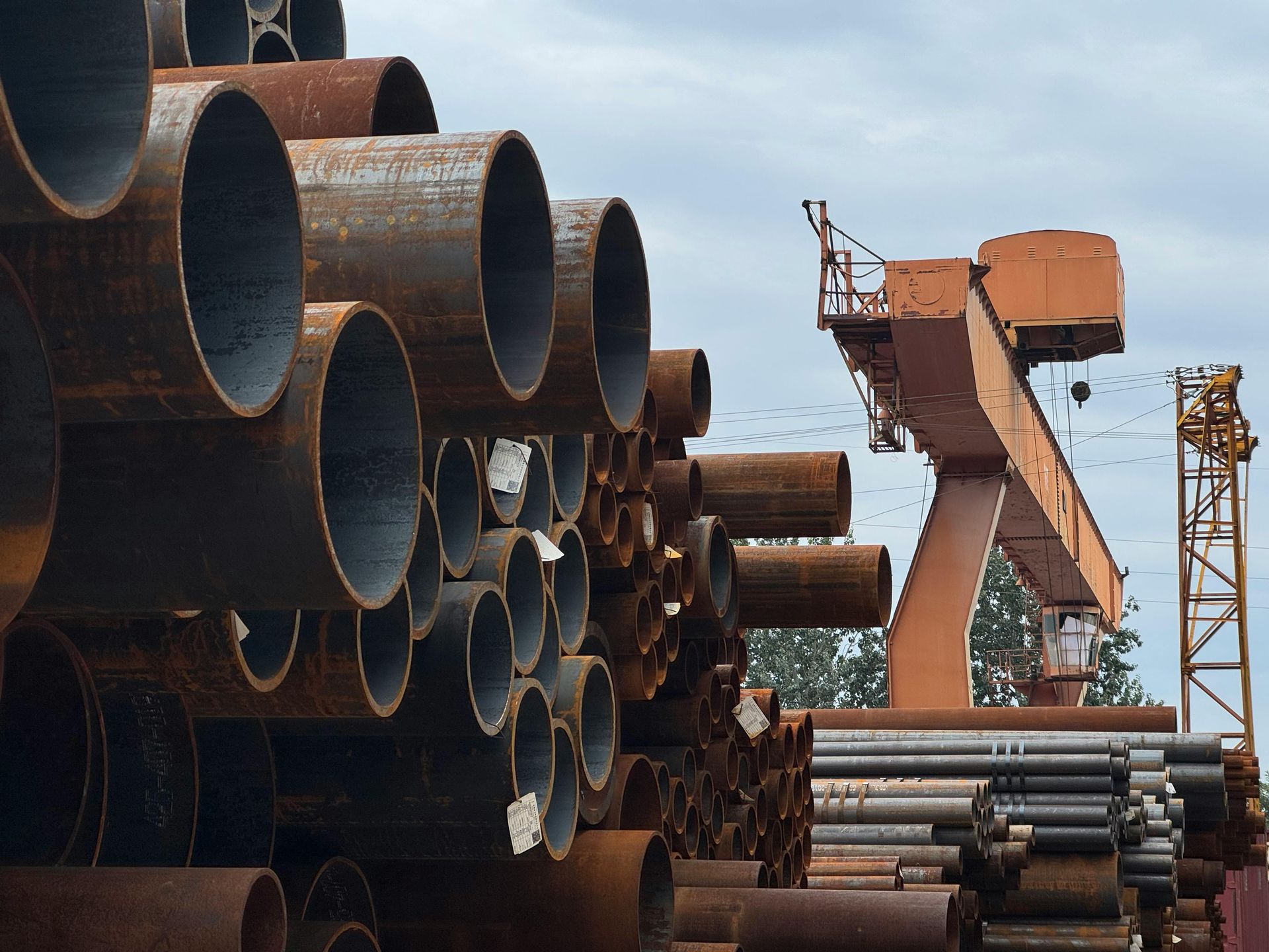Steel pipes stored in industrial yard for energy infrastructure logistics
